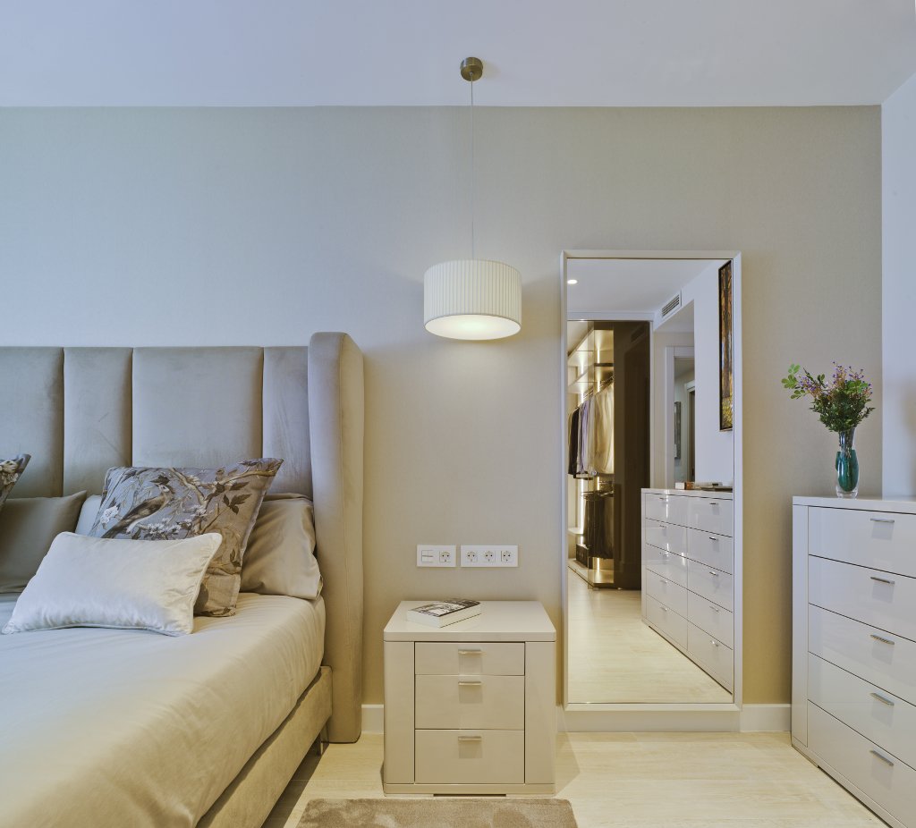Dormitorio de diseño moderno, cama, cómoda, mesilla de noche y espejo